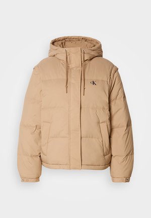 Beige puffer-jakki, jossa on huppu, vetoketjukiinnitys, kaksi sivutaskua ja pieni logo vasemmassa rinnassa. Pehmeä, tilkkutäkkitekstuuri.