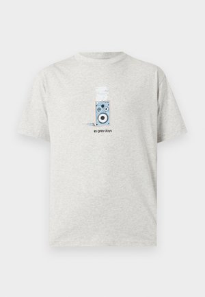 Hellgraues T-Shirt mit einer Grafik eines Lautsprechers und Papieren darüber sowie dem Text „graue Tage“ unter der Grafik.