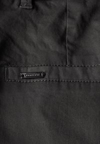 Zwarte stof met een gladde textuur heeft een gestikte zak. Inclusief een rechthoekig etiket met "Street One" in een subtiel ontwerp.