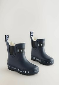 Bottes de pluie imperméables marine avec doublure blanche douce, panneaux latéraux en élastique noir et détails de marque sur la sangle et la semelle. Semelle texturée pour une meilleure adhérence.