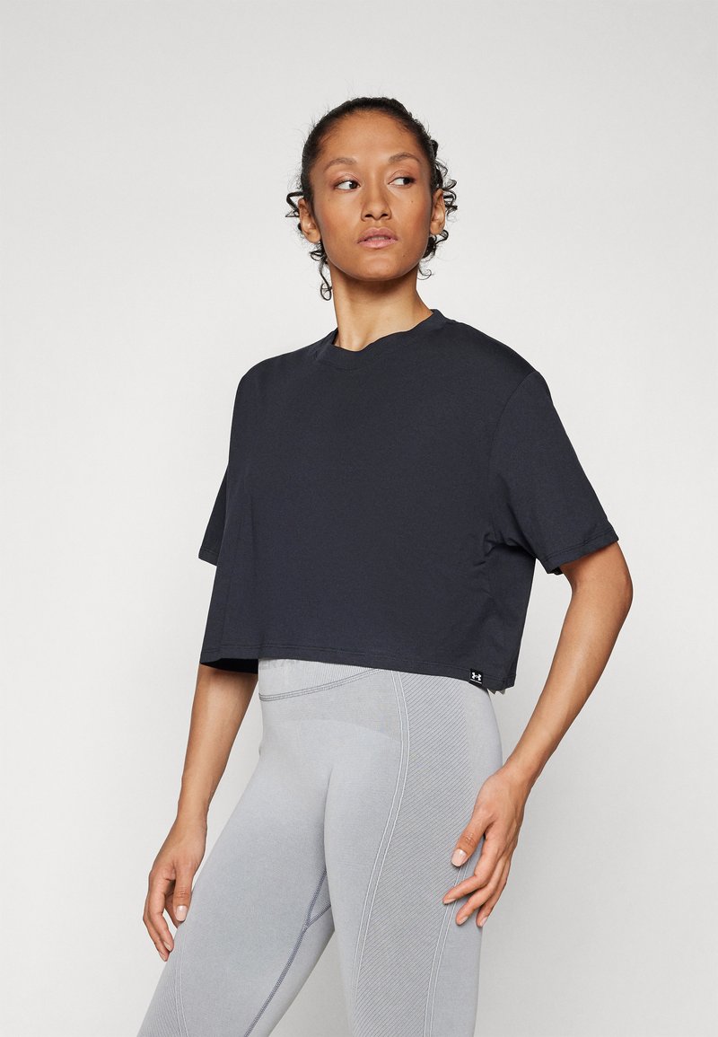 Cropped black t-shirt with short sleeves, round neckline, and understated design. Worn with light grey textured leggings.