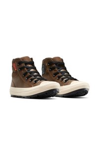 Bruine hoge sneakers met zwarte veters, rubberen zool, beige neuskap, logo-patch aan de zijkant en een gestructureerd bovensmateriaal.