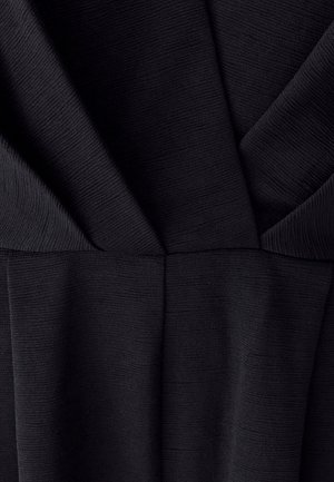 Tessuto nero con un motivo testurizzato e a costine. Il design presenta pieghe drappeggiate e una sezione strutturata in vita.