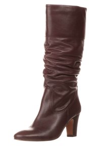 Bota de cuero burdeos hasta la rodilla con un diseño arrugado, puntera afilada y tacón apilado. Textura suave con un detalle mínimo.