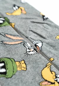 Calze grigie con personaggi dei cartoni animati, tra cui Bugs Bunny, Daffy Duck e Marvin il Marziano, con design colorati e lavorati a maglia.