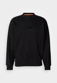 Sweat-shirt noir à manches longues avec poignets et ourlet côtelés, col rond, et petit logo "BOSS" brodé au centre de la poitrine.