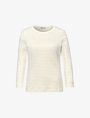 Vaalean kermanvärinen pitkähihainen T-paita, jossa ohuet beiget vaakaraitarit. Pehmeä kangas, pyöreä pääntie ja rento istuvuus.