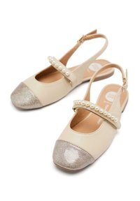 Zapatos slingback de cuero beige con una punta metálica plateada brillante y una tira decorativa acentuada con perlas blancas. Diseño de tacón plano.
