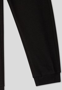 Czarne bawełniane dresy o tapered designie, z ribbowanymi mankietami i detalami szycia po bokach, zapewniającymi dopasowany krój.