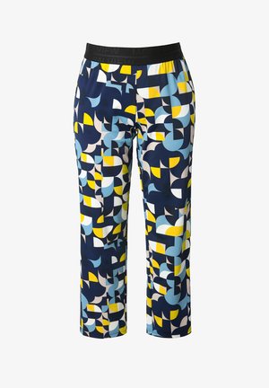 Väljäleikkaiset housut, joissa on geometrinen kuvio sinisen eri sävyissä, keltaista ja valkoista, ja musta joustava vyötärönauha.