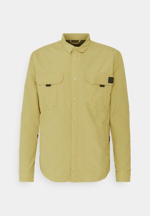 Light yellow button-up shirt made of smooth fabric, featuring two chest pockets, black accents, and a classic collar design.