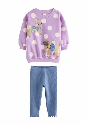 Lila Sweatshirt mit weißen Baumwollpunkten und Tierapplikationen; kombiniert mit blauen Rippleggings. Weiches Material, elastische Bündchen und gewellter Saum.