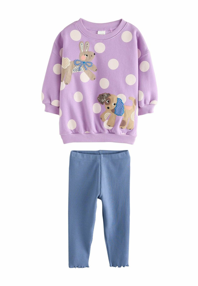 Sudadera morada con lunares blancos y aplicaciones de animales; combinada con leggings azules de canalé. Material suave, puños elásticos y dobladillo en forma de pico.