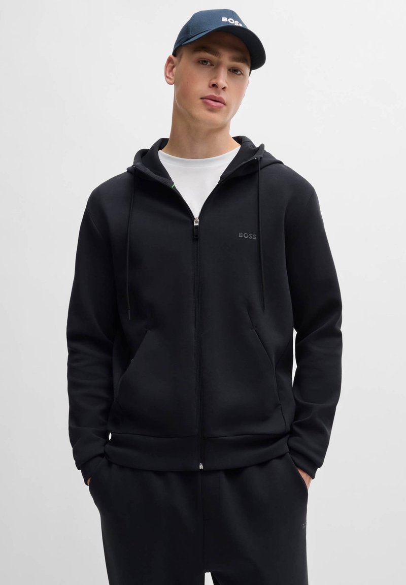 Black zip-up hoodie made of soft fabric with a drawstring hood and front pockets. Features a subtle embroidered logo on the chest.