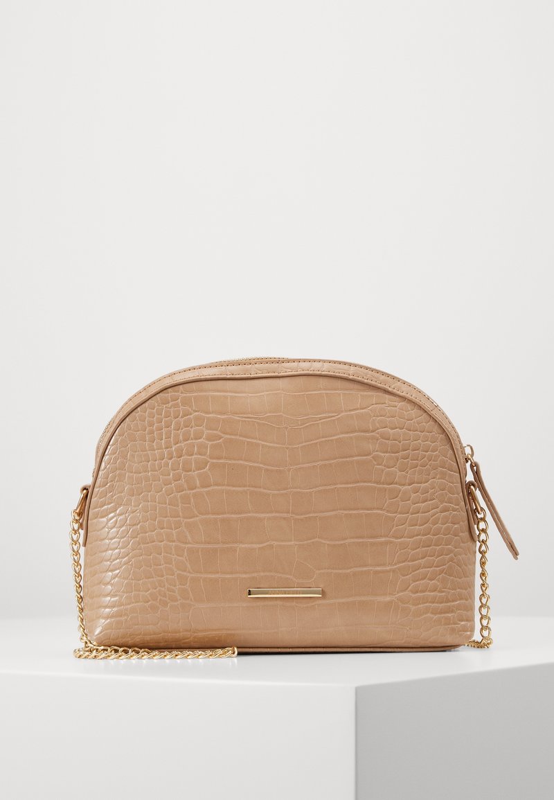 Borsa in finta pelle color cuoio con motivo a coccodrillo testurizzato, forma arrotondata e tracolla a catena dorata. Caratterizzata da un dettaglio in metallo dorato sul davanti.