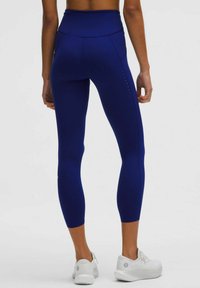 Marinblå leggings med hög midja har texturerad sömnad och en slät yta. Inkluderar subtil logotypdetalj vid vaden.