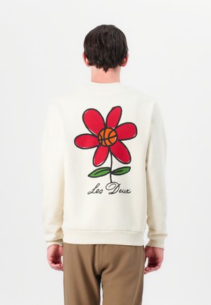 Sweatshirt crème avec un grand motif de fleur rouge au centre de basket, des feuilles vertes et "Les Deux" brodé en cursif noir.