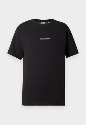 T-shirt de algodão preto com mangas curtas, design de gola redonda, apresenta "Tower Bridge" bordado em branco no peito.