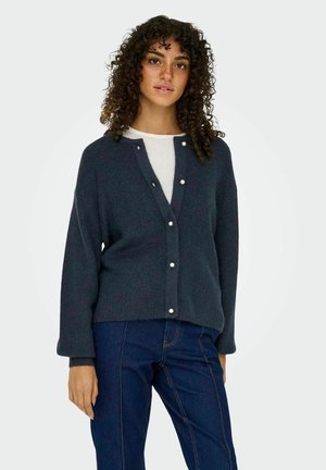Donkerblauwe cardigan van een gemêleerd breisel, met een V-hals, sluiting met witte parels aan de voorkant en mouwtjes in een ontspannen pasvorm.