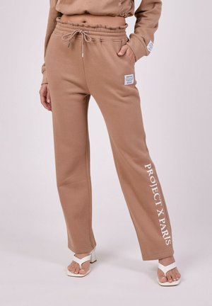 Pantalons de survêtement marron en tissu doux, dotés d'une taille à cordon de serrage et d'un motif imprimé "PROJECT X PARIS" sur le côté.