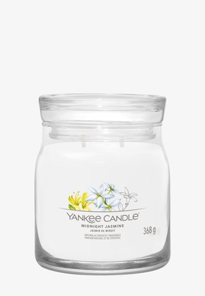 Glazen potkaars met het label "Yankee Candle Midnight Jasmine" met illustraties van gele en witte jasmijnbloemen, gewicht 368g.