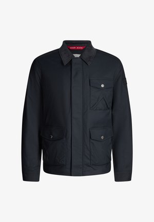 Granatowa kurtka materiałowa z klasycznym kołnierzem, dwoma kieszeniami na piersi i zapięciem na guziki. Charakteryzuje się subtelną fakturą i srebrnymi detalami.