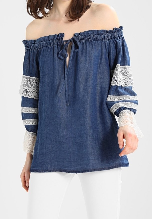 Haut en denim à épaules dénudées avec col à volants, détail de lien et manches accent en dentelle présentant des rayures horizontales blanches. Coupe décontractée.