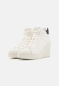 Białe sneakersy za kostkę z teksturowanym noskiem typu shell, wiązane na sznurówki, z koturnem. Czarny akcent z tyłu. Gładka syntetyczna cholewka.