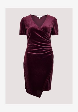 Korte mouw wikkel jurk in diep bordeauxrood, gemaakt van zachte fluweel. Kenmerkt een V-halslijn en geplooide details aan de zijkant voor extra textuur.
