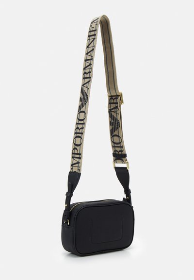 Sac bandoulière noir texturé avec une fermeture éclair dorée, doté d'une sangle beige affichant "Emporio Armani" en noir. Forme rectangulaire, design compact.