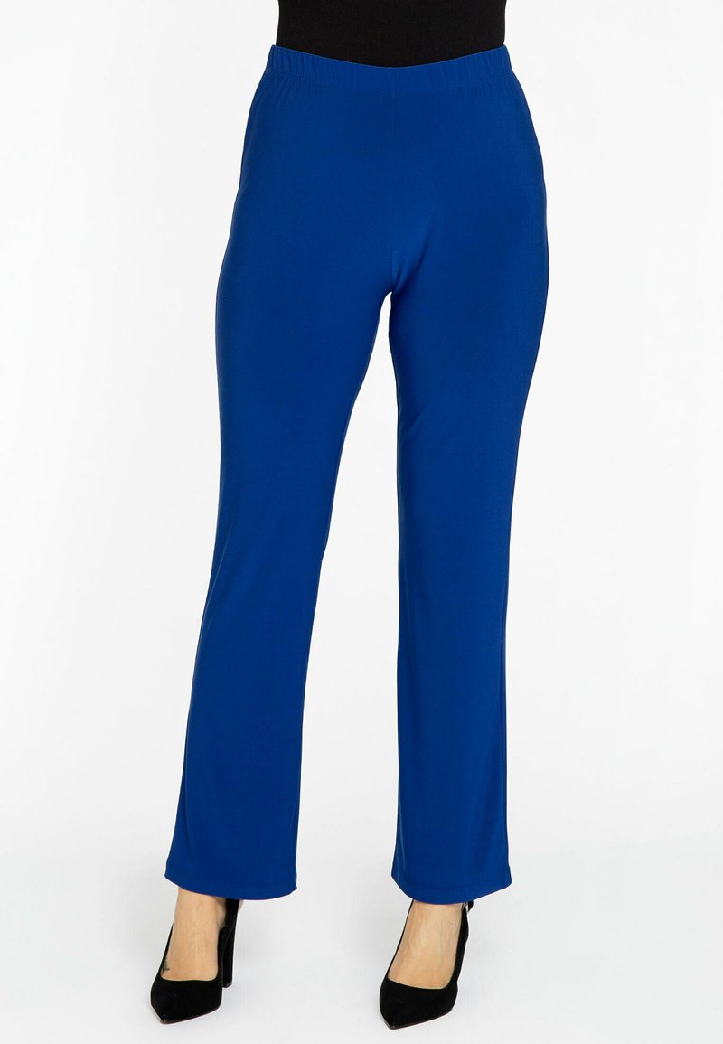 Blauwe stretchbroek met een elastische tailleband, recht toelopende pijpen, soepele textuur en een volledige lengte, gecombineerd met zwarte hoge hakken.