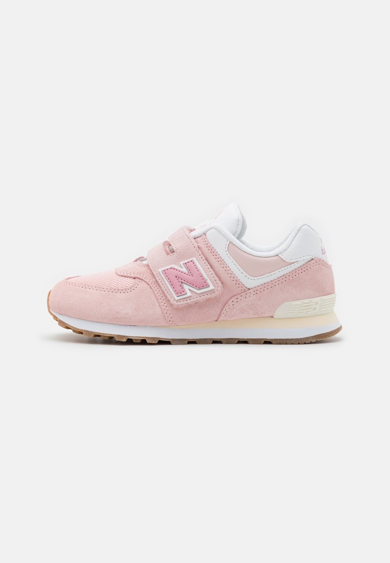 Baskets New Balance rose clair et blanches avec bandes velcro, détails en daim et mesh, et semelle en gomme.