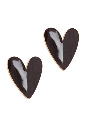 Paire de boucles d'oreilles clous en émail noir en forme de cœur avec des bords dorés sur un fond blanc.