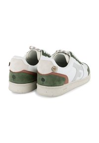Sneaker blanc avec des accents en daim vert, une section de talon beige et des coutures décoratives. Dispose d'une semelle texturée et d'un détail de logo.