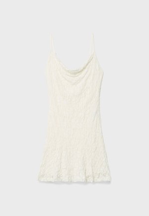 Weiße Spitzen-Camisole mit dünnen Spaghettiträgern, mit einem drapierten Ausschnitt und einem ausgestellten Saum. Texturiertes Material mit floralem Muster.