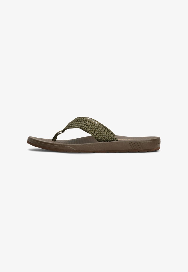 Bruine flip-flop sandaal met een geweven groene band, platte vormgeving, textuur voetbed en een flexibele rubberen zool. Heeft merkvermelding op de band.