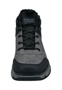 Sneaker grigio con accenti neri, tomaia sintetica testurizzata, punta rinforzata e lacci neri. Logo sulla linguetta e suola in gomma resistente.