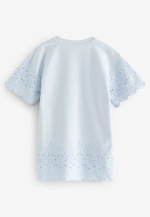 Világoskék pamut póló fodros ujjakkal és hímzett virágmintákkal az alján, világoskék díszítésekkel és kivágott részletekkel.