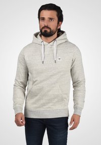 Lichtgrijze hoodie gemaakt van zachte stof, met een voorzak, trekkoorden en een klein logo op de borst.