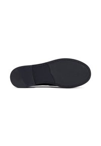 Semelle de chaussure noire avec une surface texturée, présentant une forme arrondie et des bords cousus, conçue pour la durabilité et l'adhérence.