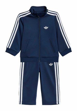 Granatowy dres dla malucha z białymi paskami Adidas na rękawach i nogawkach, kurtka na zamek i elastyczne mankiety.