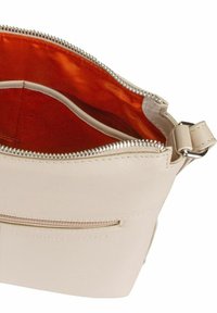 Light beige leather bag with a zip closure, featuring an orange lining and an exterior zip pocket. Smooth texture with a minimal design.