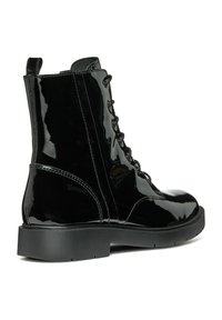 Bottine en cuir verni noir avec un laçage à l'avant, bout rond et semelle épaisse noire. Texture lisse avec des détails de couture visibles.