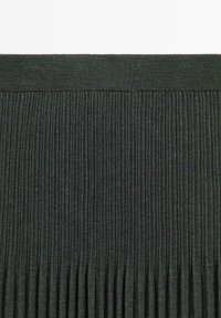 Tissu tricoté côtelé vertical gris foncé avec une ceinture unie, montrant la texture et le motif de près.