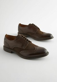 Braune Leder-Dressschuhe mit Brogue-Details, die eine glatte Kappen- und strukturierte Einsätze aufweisen. Schnürdesign und runde Zehen.