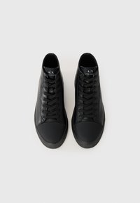 Schwarze High-Top-Sneaker aus strukturiertem Leder mit einer glatten Gummikappe, ausgestattet mit schwarzen Schnürsenkeln und Logoschildern auf den Zungen.