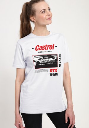Junge Frau trägt ein weißes T-Shirt mit schwarzem und rotem Castrol GTX Rennwagen-Grafik und japanischem Text, schaut nach oben und rechts.