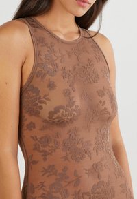 Brązowy tank top z haftem kwiatowym, cechujący się bezrękawowym fasonem i dopasowanym krojem, wykonany z przezroczystej, teksturowanej tkaniny.