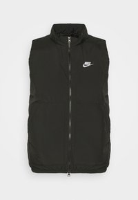 Crna prsluk bez rukava sa prednjim patentnim zatvaračem, visokim ovratnikom, dva prednja džepa i bijelim Nike logom na lijevoj strani grudi. Glatka tekstura.