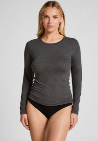 Lange mouwen shirt in donkergrijs, gemaakt van zachte, rekbare stof. Heeft een ronde halslijn en een aansluitend ontwerp, gecombineerd met zwarte boxershorts.